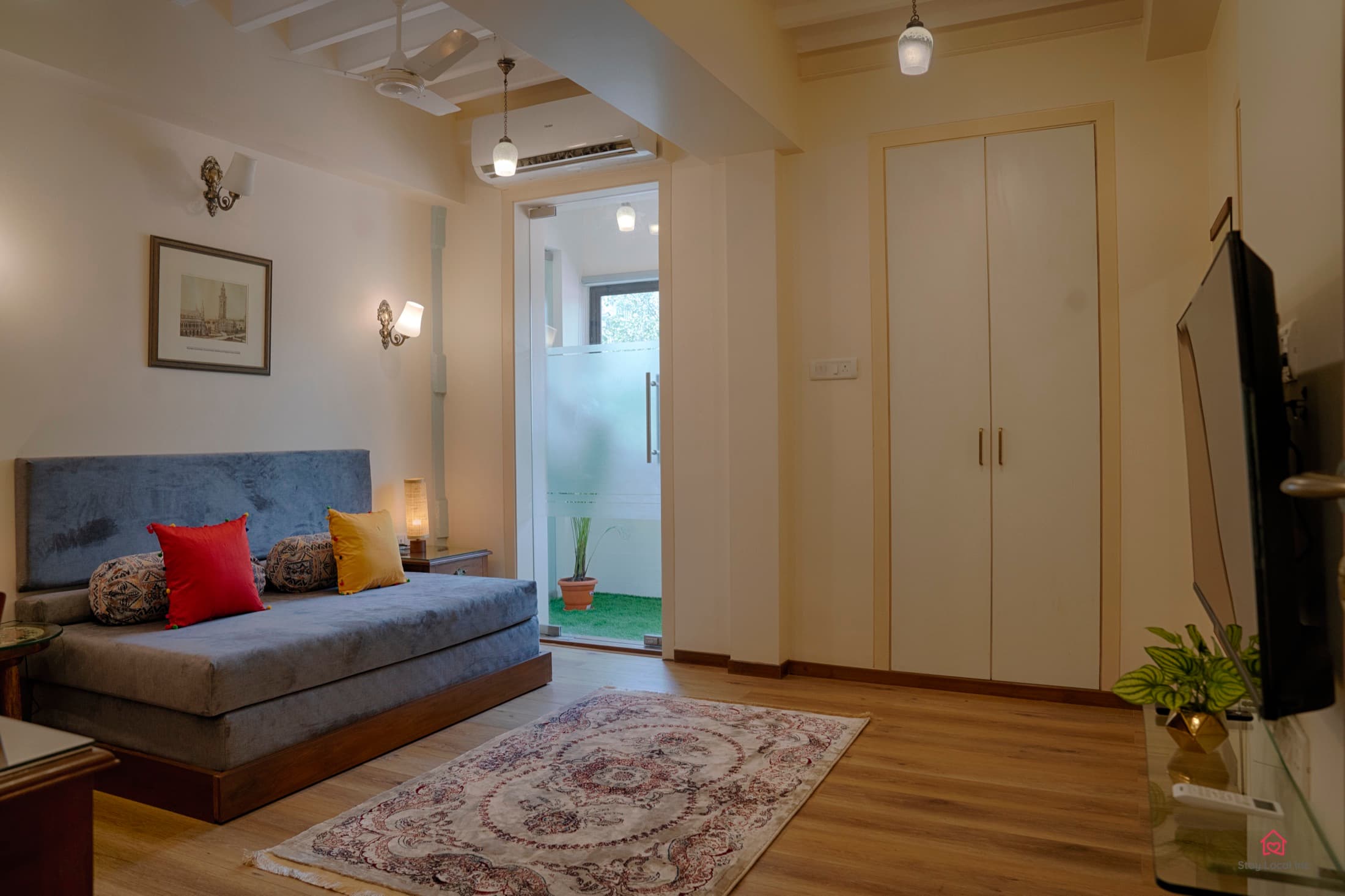 Furnished room with daybed, wardrobe and television